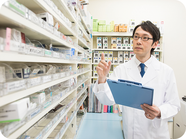 薬剤師がクリップボードを持って立っている様子